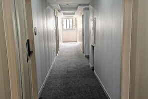 A long, narrow hallway with carpeted floors and doors on both sides. - Huashuyi Hostel (Shanghai Kongjiang Road) (Shanghai)