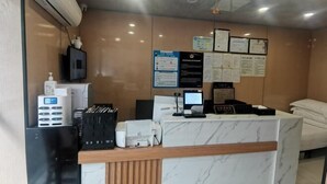 A hotel reception area with a marble counter, a computer, a printer, and various informational posters on the wall. - Huashuyi Hostel (Shanghai Kongjiang Road) (Shanghai)