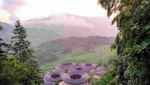 Un conjunto de edificios con techos redondeados, ubicados en un paisaje montañoso y exuberante.