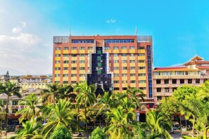 A multi-story hotel with a central atrium and a red roof. - Gemeng Hotel (Xishuangbanna Xuanwei Avenue) (Jinghong)