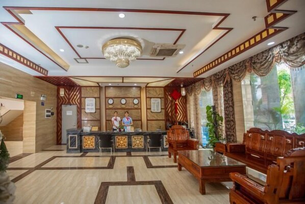 A hotel lobby with a reception desk, seating area, and a chandelier. - Gemeng Hotel (Xishuangbanna Xuanwei Avenue) (Jinghong)