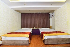 A hotel room with two single beds, a small table, and a curtain. - Gemeng Hotel (Xishuangbanna Xuanwei Avenue) (Jinghong)