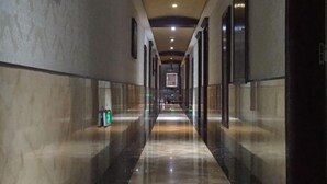 A long, narrow hallway with a polished floor and framed pictures on the walls. - Gemeng Hotel (Xishuangbanna Xuanwei Avenue) (Jinghong)