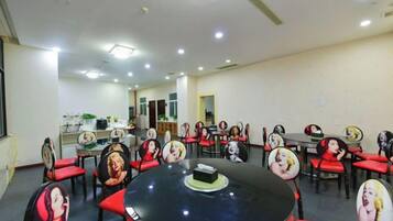 A conference room with a round table, red chairs, and a whiteboard.
