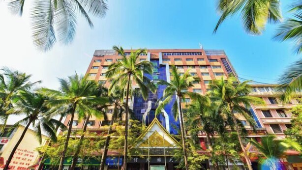 A multi-story hotel with a modern facade, surrounded by palm trees. - Gemeng Hotel (Xishuangbanna Xuanwei Avenue) (Jinghong)