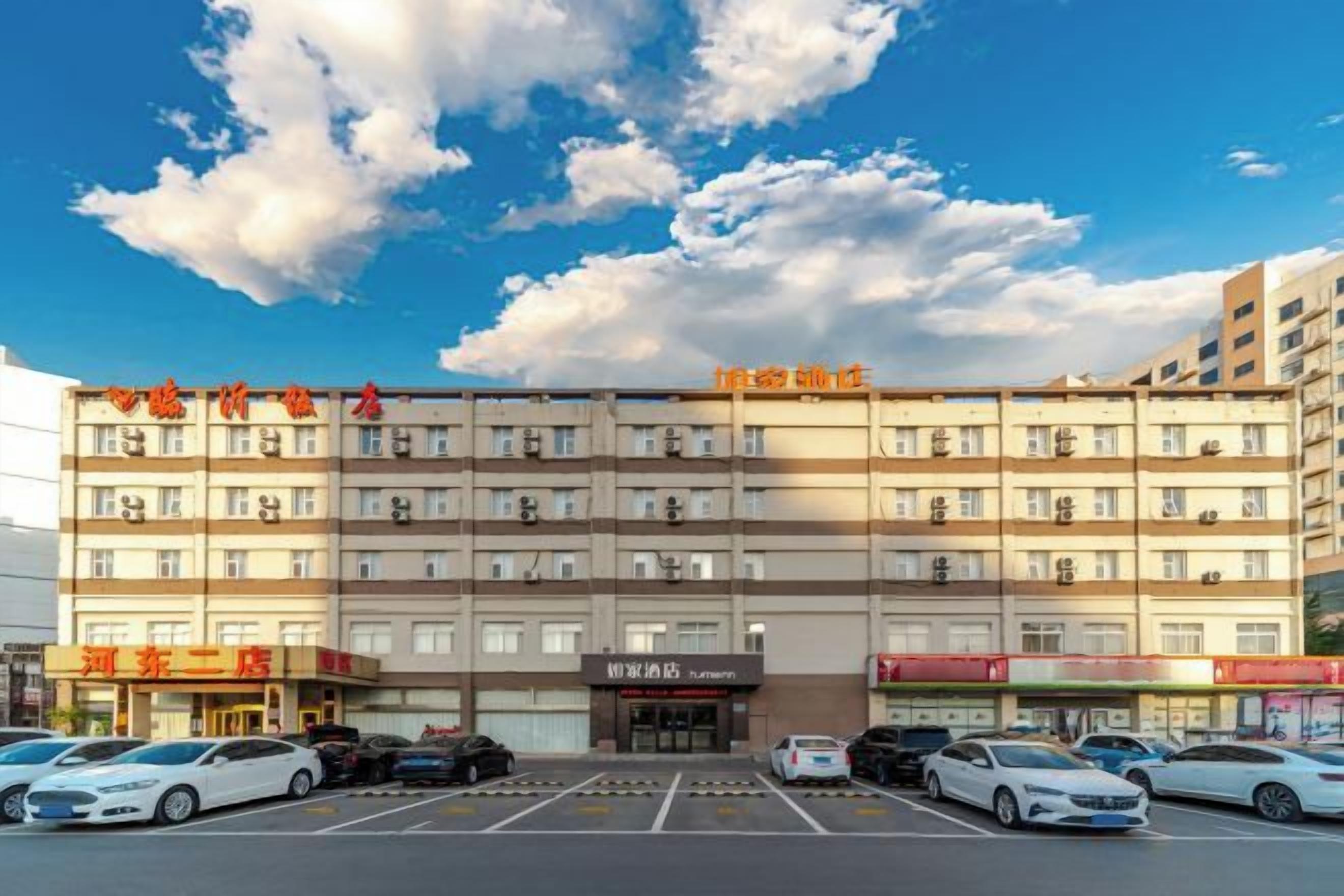 A multi-story hotel with a parking lot in front.