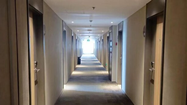 A long, narrow hotel corridor with doors on both sides and a carpeted floor. - HomeInn·neo（Linyi Hedong District government store） (Linyi)