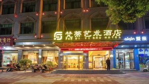 Entrada de un hotel con un letrero que dice 'Fan Di Yi Shu Hotel' y una persona parada frente a él.
