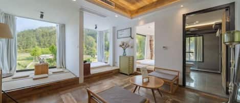 A modern interior with wooden flooring, a round table, and a bench.