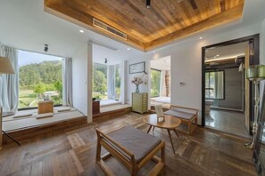 A modern interior with wooden flooring, a round table, and a bench.