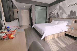 Une chambre d’hôtel avec un lit, une table de chevet et un mur orné d’un motif de feuilles.