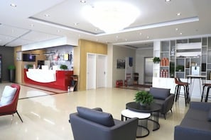 A hotel lobby with a reception desk, seating area, and a kitchenette. - Shankee Hotel (Tancheng Sifang Furniture Plaza) (Tancheng)