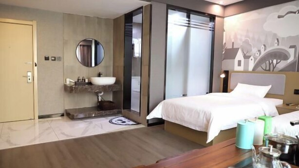 A modern hotel room with a bed, bedside table, and a large window.