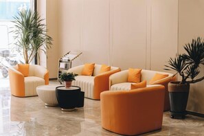 Una sala de estar moderna con un juego de sofá, un reposapiés y plantas en macetas.