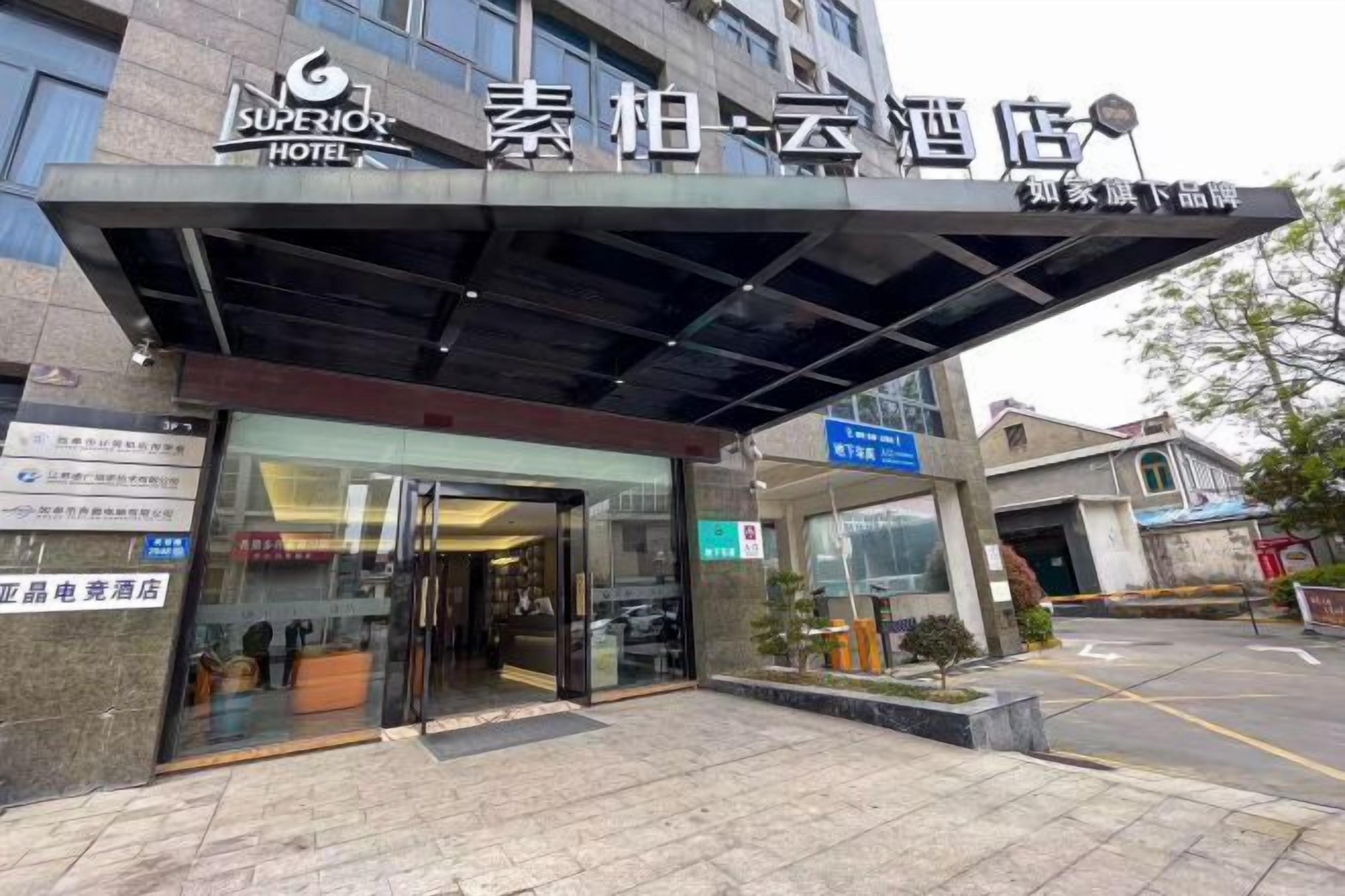 The exterior of a hotel with a modern facade, a covered entrance, and signage indicating it is a hotel.