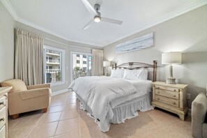 A bedroom with a bed, a chair, a nightstand, and a ceiling fan. - BEACHFRONT RESORT, FAMILY FRIENDLY, TOP AMENITIES (Orange Beach)