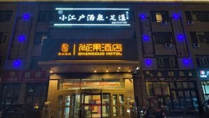 Un hotel con un letrero que dice "SHANGGUO HOTEL" y otro letrero encima que dice "小江户汤泉·浴道".