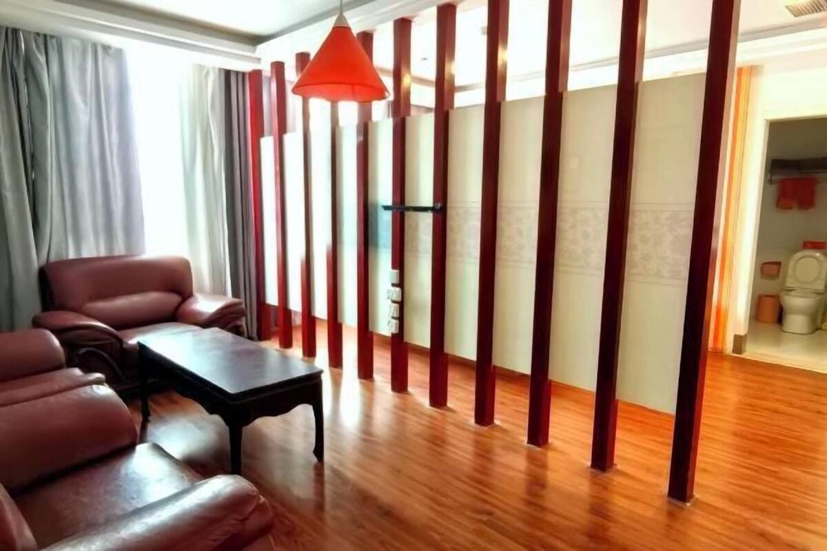 Una sala de estar moderna con un conjunto de sofás, una mesita y una lámpara colgante roja.