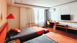 Una habitación de hotel con dos camas, un escritorio, una silla y un televisor.