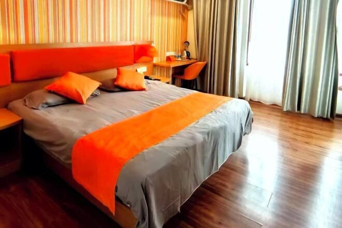 Una habitación de hotel con una cama, un escritorio y una silla.