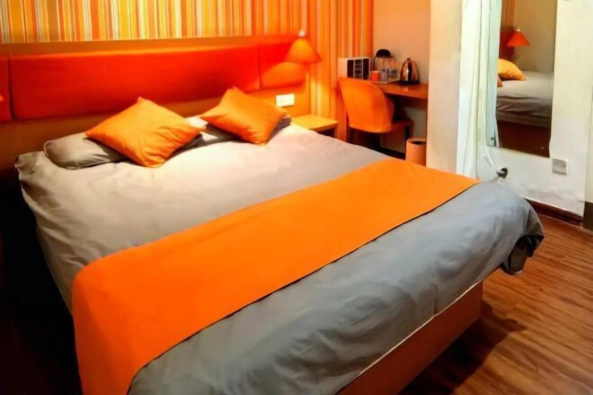 Una habitación de hotel con una cama, un escritorio y una silla.
