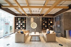 Un interior moderno con zona de estar, estanterías y un ventanal grande.