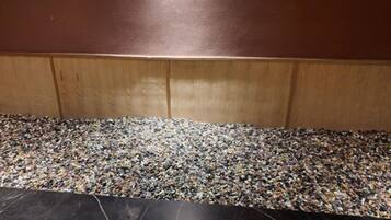 A floor with a pebble pattern and a wooden panel wall.