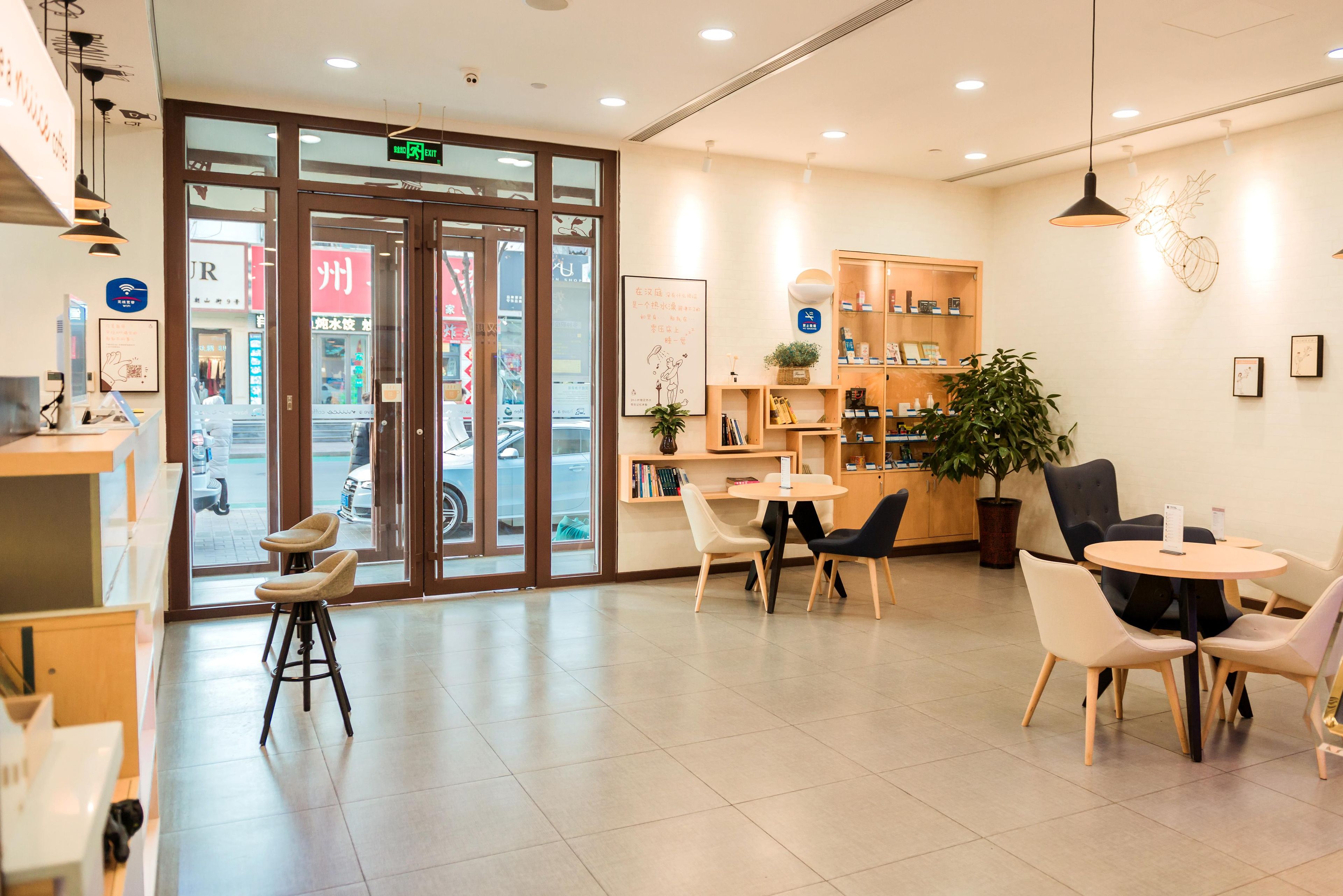 A modern interior with a reception desk, seating area, and a bookshelf.