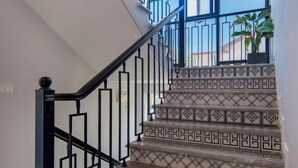 A staircase with black metal railings and patterned tiles. - Shengsiya home stay (Shengsi)