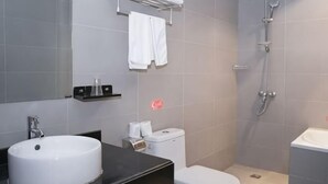 A bathroom with a sink, toilet, and shower.
