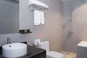 Un baño con lavamanos, inodoro y ducha.