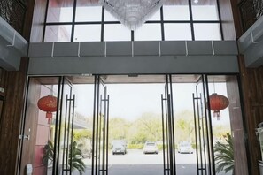 A hotel entrance with a glass door, a chandelier, and red lanterns. - Pudding hotel (Shanghai Chongming Dongtan store) (Shanghai)