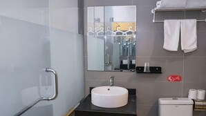 A modern bathroom with a white sink, a mirror, a towel rack, and a toilet.
