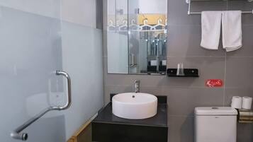 A modern bathroom with a white sink, a mirror, a towel rack, and a toilet.