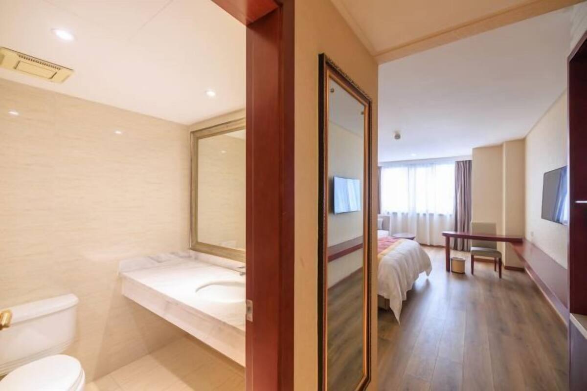 Une chambre d’hôtel avec salle de bain, un lit, une télévision et un bureau.