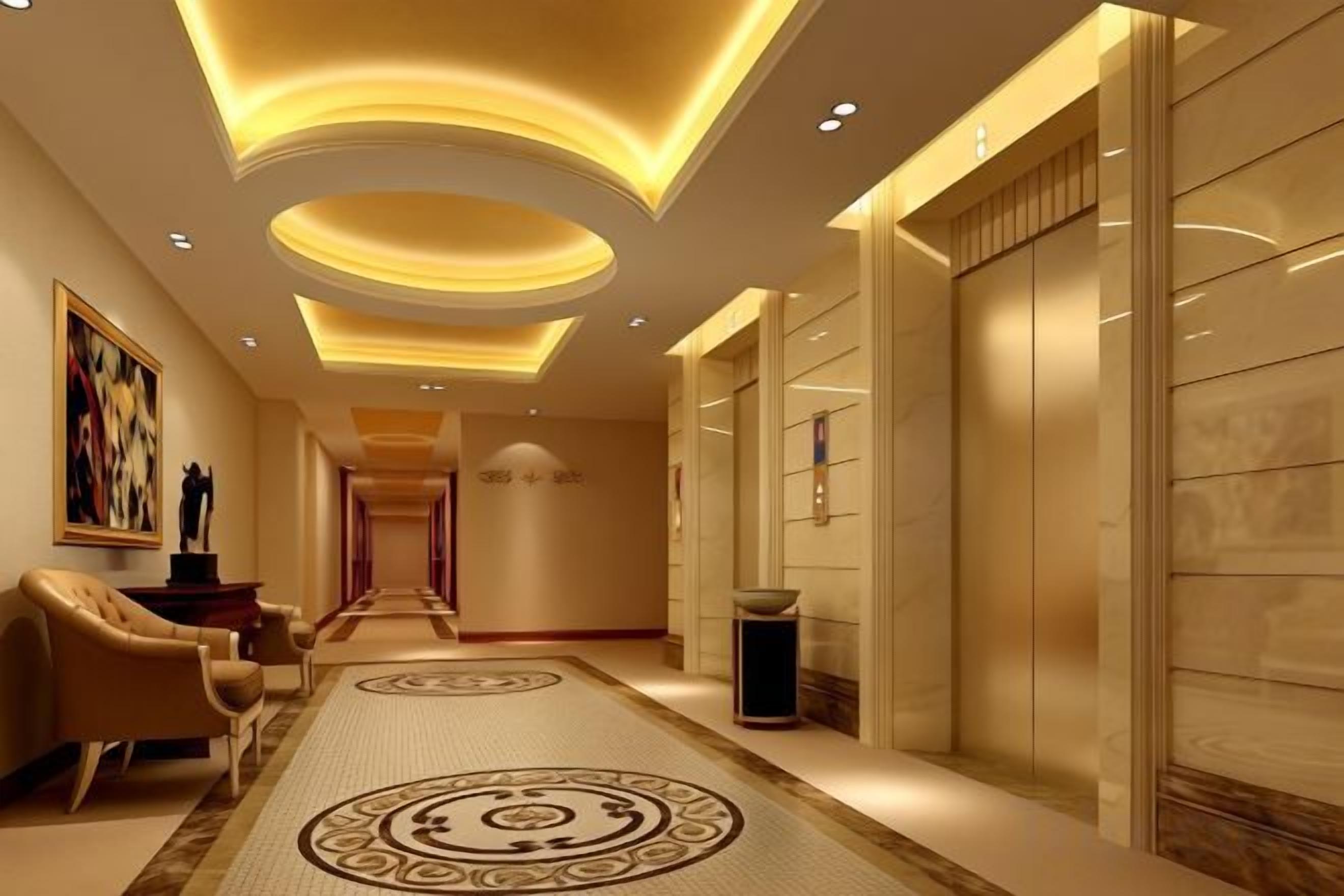 A hotel hallway with a patterned carpet, a sofa, a trash bin, and a wall-mounted light fixture.