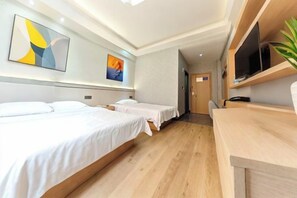 Una habitación de hotel con dos camas, un escritorio y un televisor.