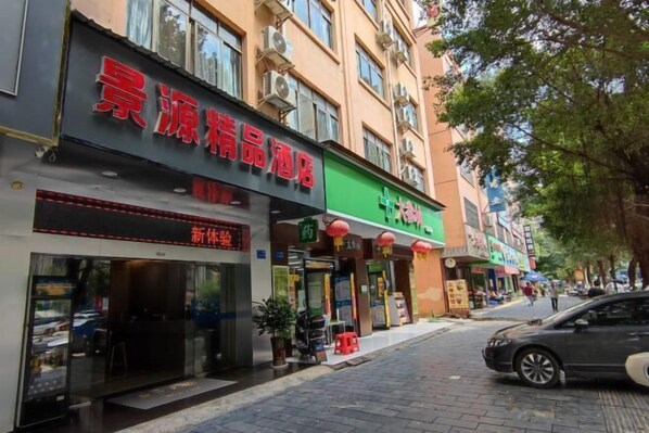 A street view with a hotel named "Accurate" on the left, featuring a modern facade and large windows.
