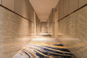 A corridor with marble flooring and walls, leading to a door. - 123 Hotel (Taizhou)