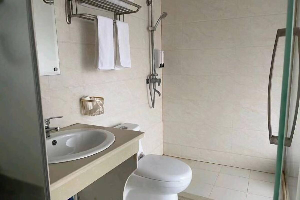 A bathroom with a sink, toilet, and shower.