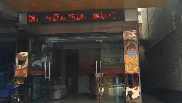 A storefront with a glass entrance, a digital display above the door, and various items inside. - Bai Ying Hostel (Shanghai)