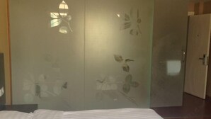 Un dormitorio con cama, un armario decorado con motivos florales y una puerta.