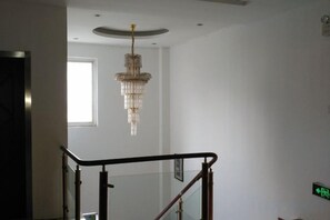 A staircase with a glass railing and a chandelier. - DONG FANG LUO MA (Wuhu)