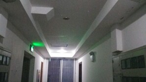 Un pasillo estrecho con paredes blancas e iluminación empotrada en el techo.