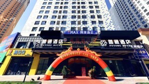 A hotel entrance with a large archway and multiple signs, including one for Putong Hotel.