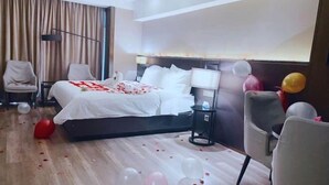 A hotel room with a bed, bedside tables, a lamp, and a chair.