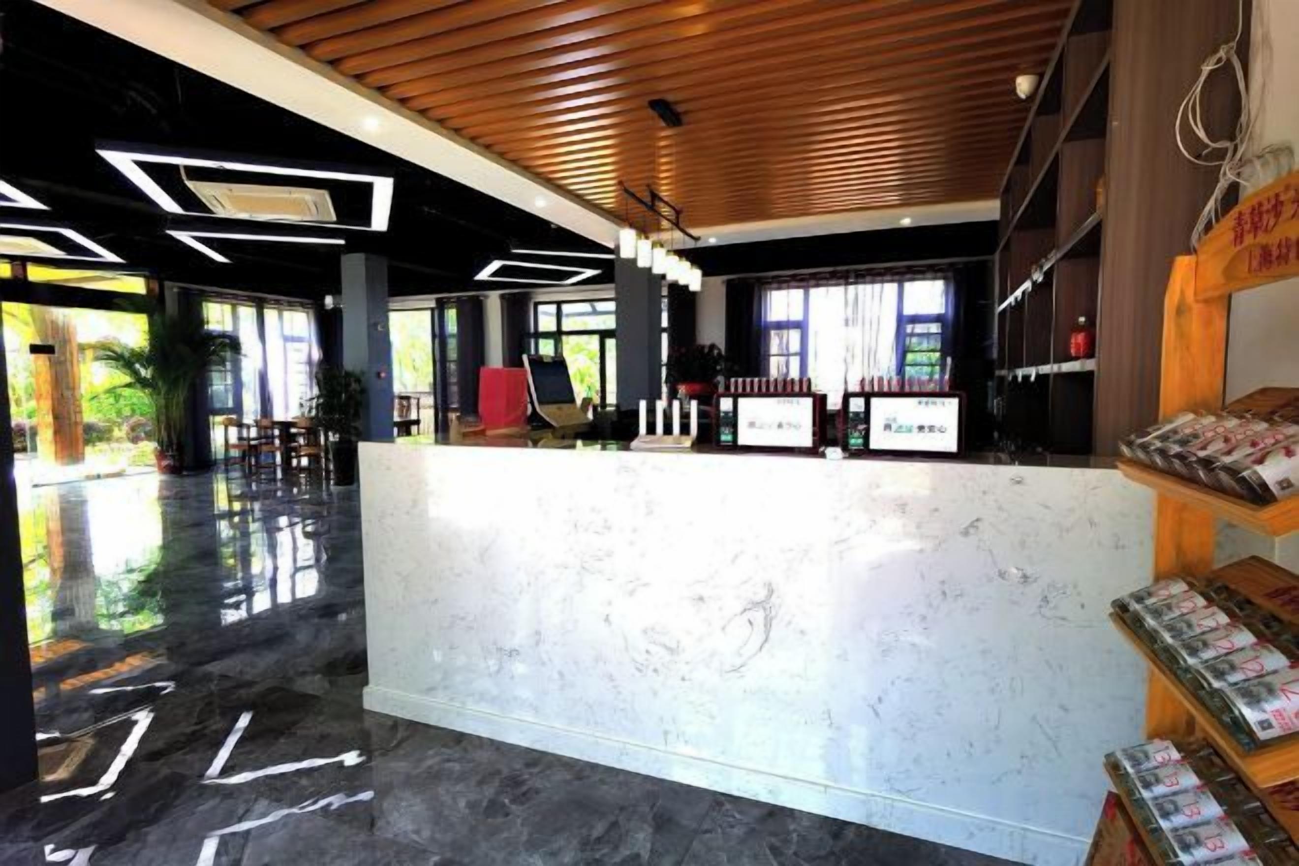 A reception area with a marble counter, wooden ceiling, and a magazine rack.