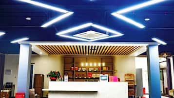 A reception area with a counter, seating, and a plant.