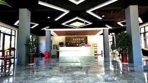 A spacious lobby with a marble floor, a reception desk, and modern lighting fixtures. - Donglai Manor Hotel (Shanghai)