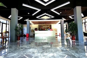 A spacious lobby with a marble floor, a reception desk, and modern lighting fixtures. - Donglai Manor Hotel (Shanghai)